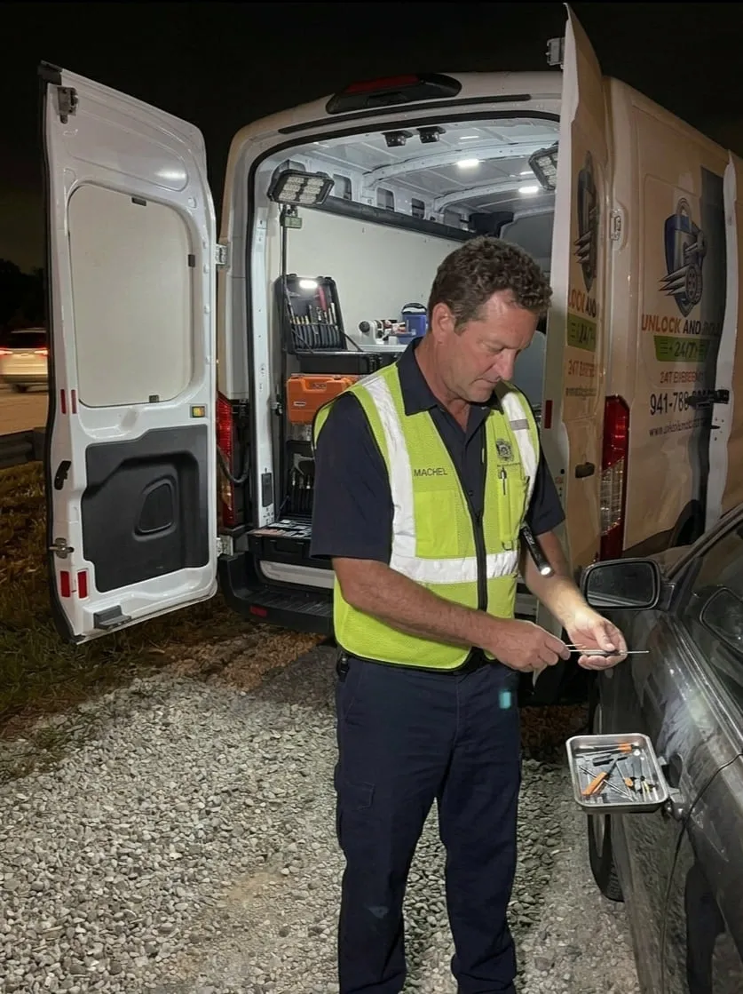 Unlock and Roll 24-7 technician working a roadside vehicle lockout at night with the van doors open